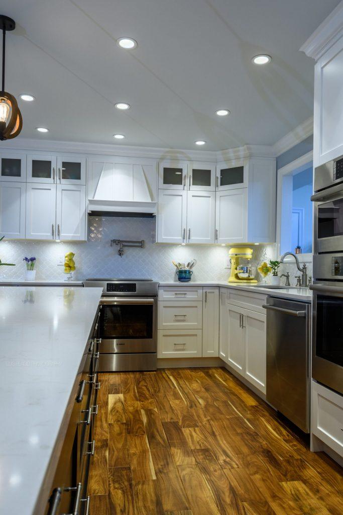 Custom wooden hood fan over the range with white maple shaker cabinets and a white quartz countertop, Port Coquitlam kitchen renovation