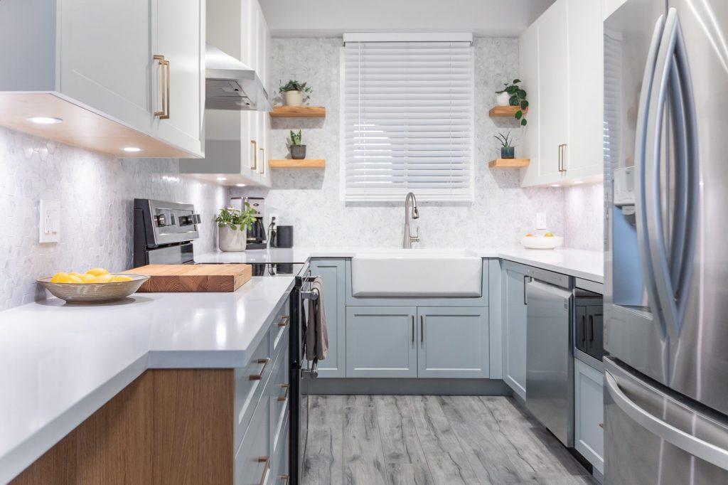 White and blue-grey shaker cabinets with a farmhouse sink, open wood shelves and stainless appliances, Vancouver kitchen renovation