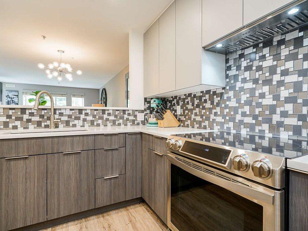 White slab uppers over grey woodgrain lowers with a custom flush hood fan and mosaic backsplash, Quayside townhouse kitchen renovation in New Westminster